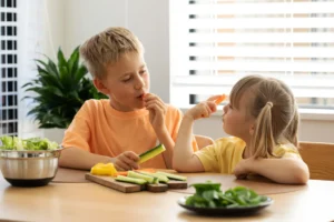 due bambini che mangiano della verdura